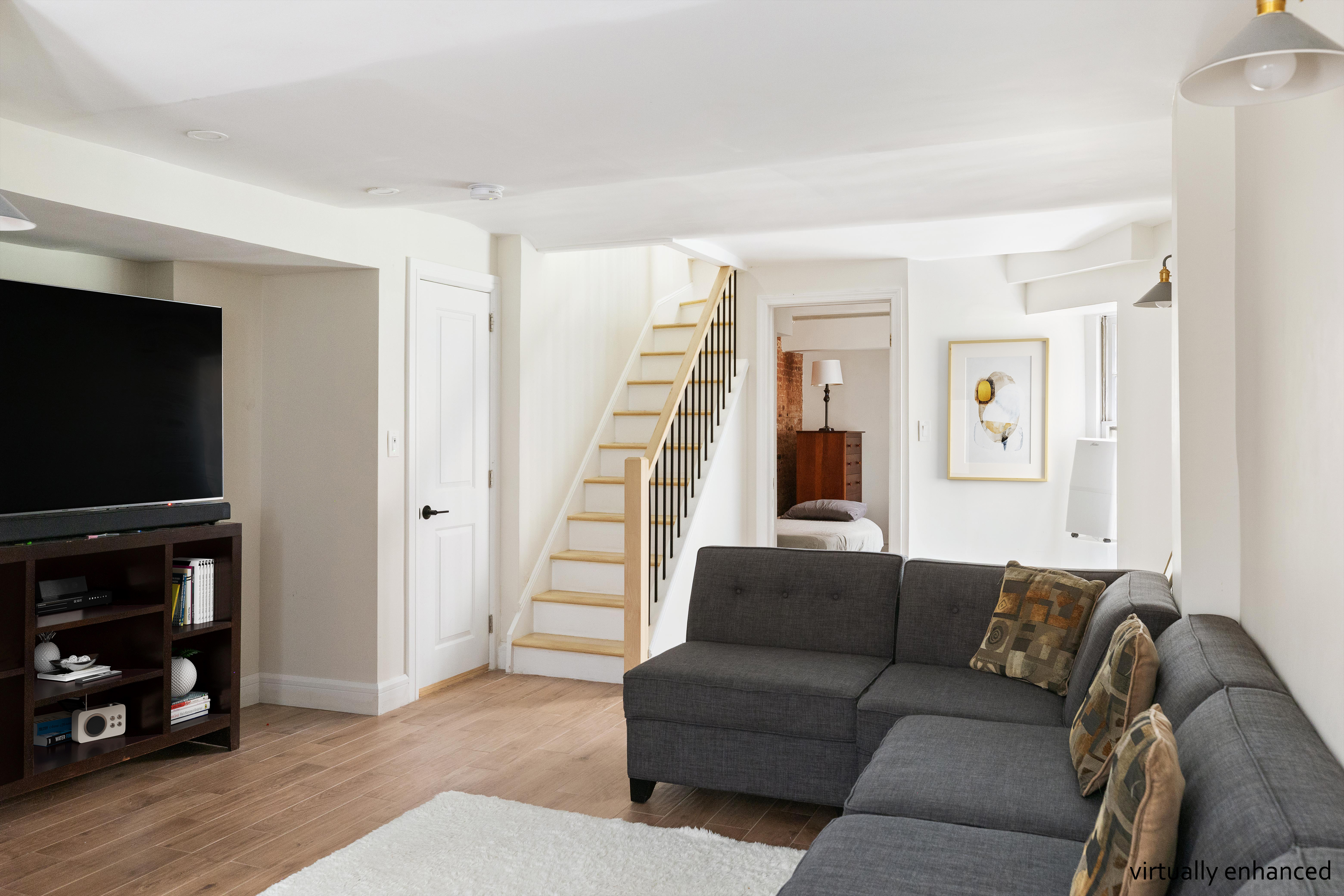330 East 94th Street, Unit 1AB Manhattan, NY 10128 - Photo 11 of 14 a living room with furniture and a flat screen tv