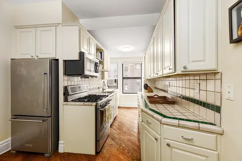 a kitchen with a refrigerator stove and white cabinets