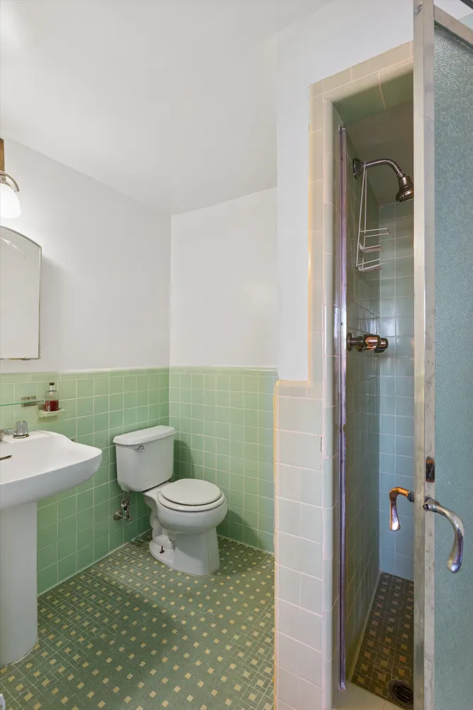 a bathroom with a sink a toilet and shower