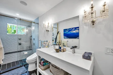 a bathroom with a sink a toilet and shower