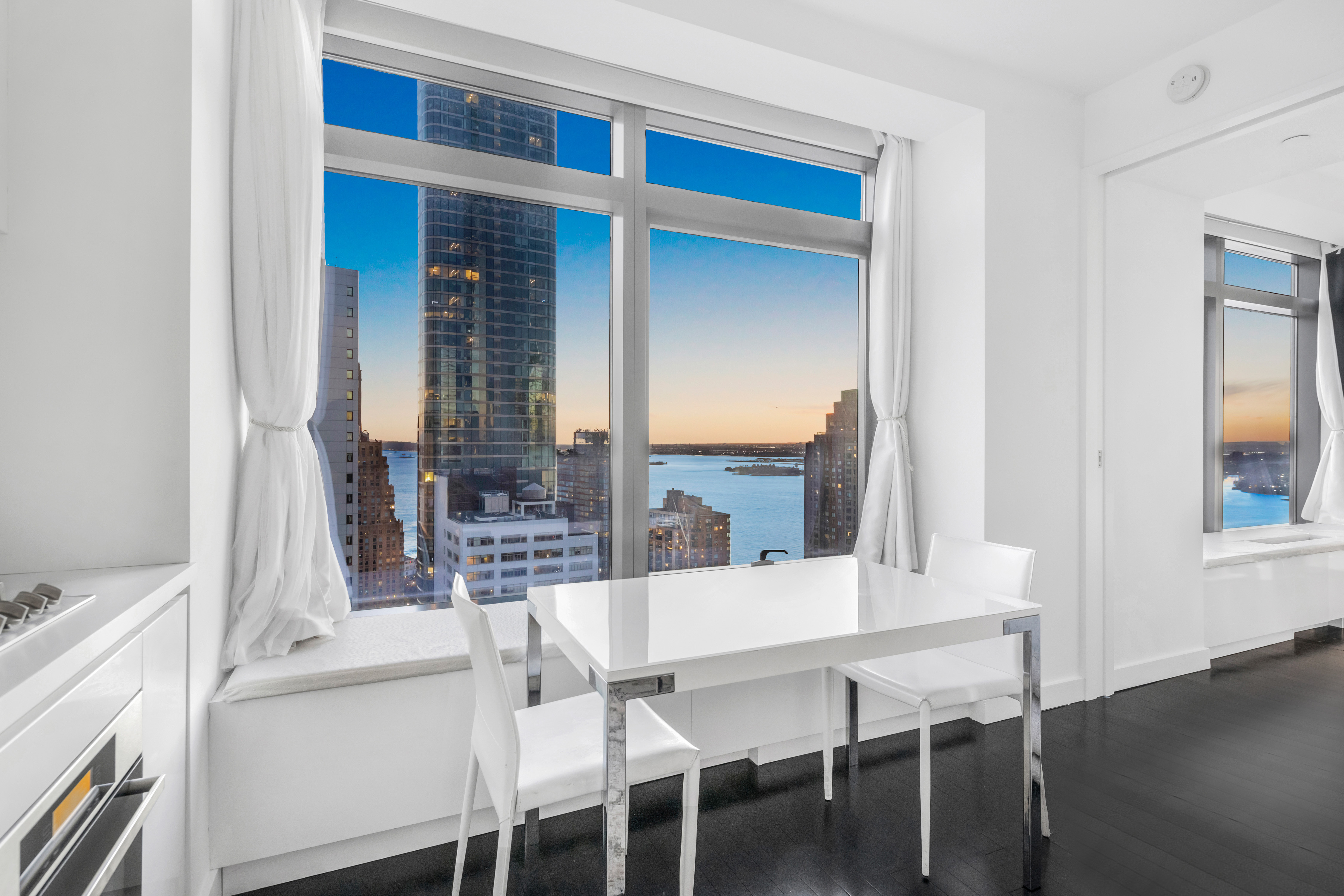 123 Washington Street, Unit 36H Manhattan, NY 10006 - Photo 1 of 8 a dining room with furniture and wooden floor