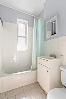 a bathroom with a sink toilet vanity and tub