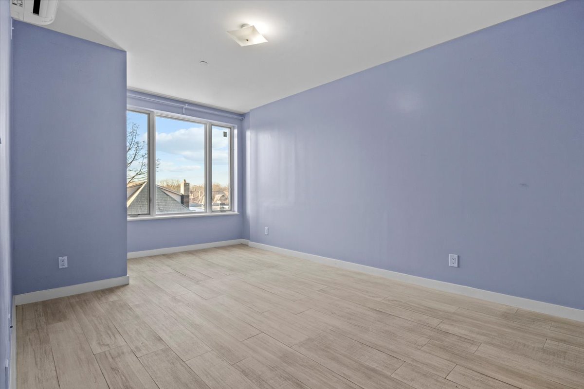 1972 Ocean Avenue, Unit 4A Brooklyn, NY 11230 - Photo 10 of 18 an empty room with wooden floor and windows