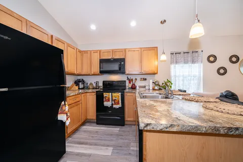 a kitchen with stainless steel appliances granite countertop a stove a sink and a refrigerator
