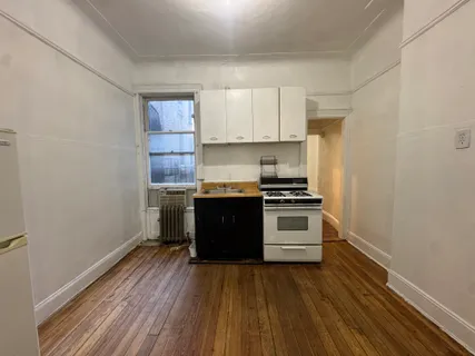 a kitchen with a stove and white cabinets