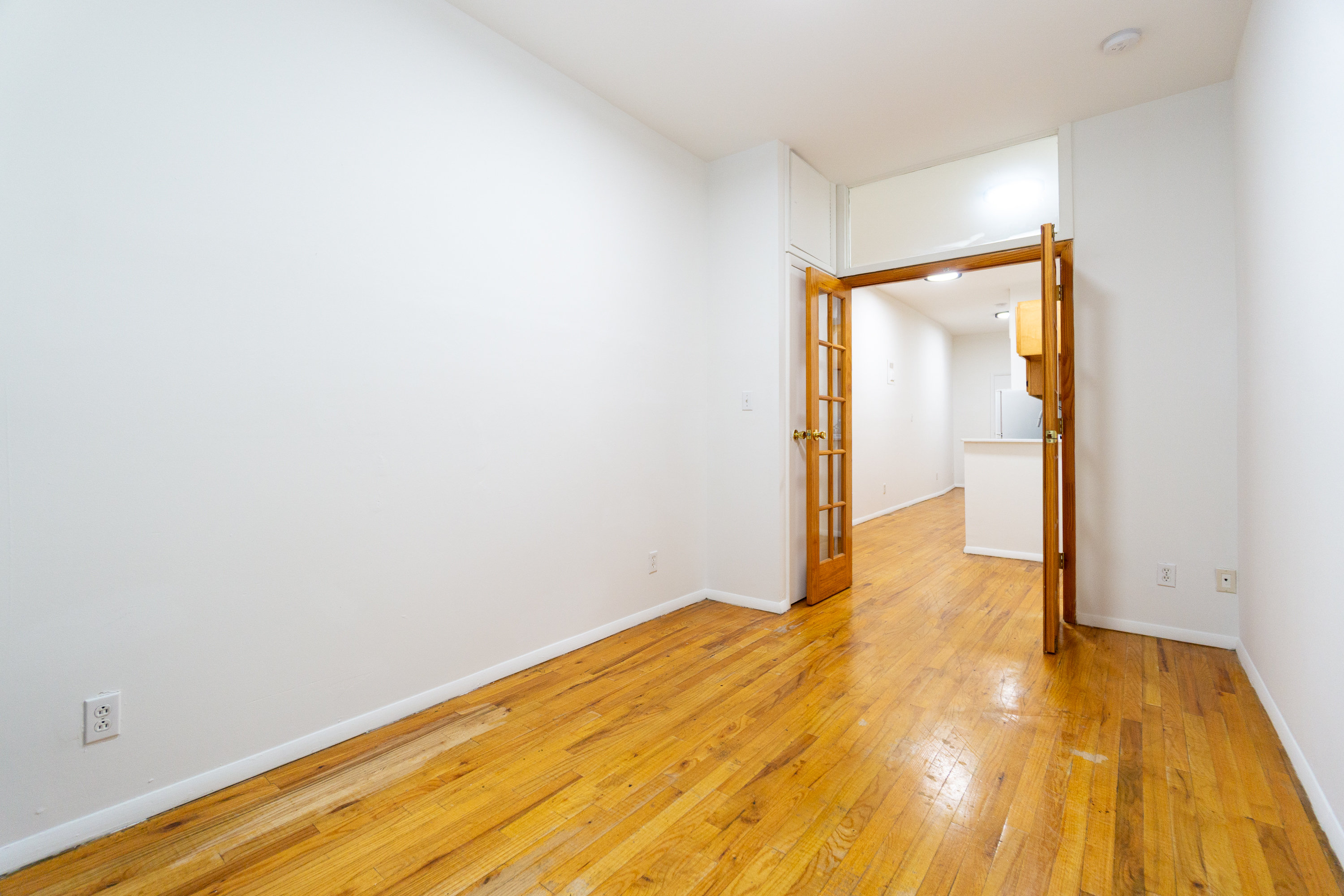 319 East 25th Street, Unit 1B Manhattan, NY 10010 - Photo 3 of 15 a view of empty room with wooden floor