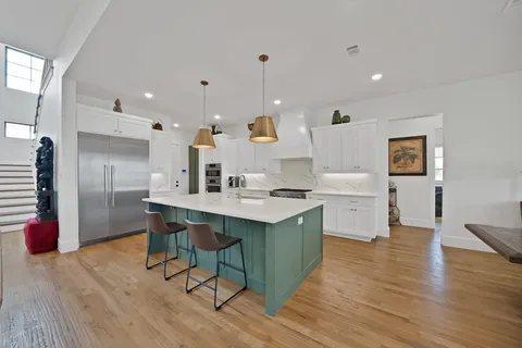 a kitchen with stainless steel appliances granite countertop a sink stove and wooden floor