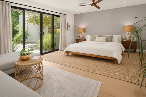a bedroom with a bed and a large window
