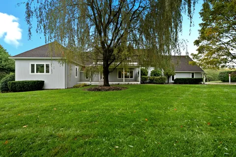 a kitchen with stainless steel appliances kitchen island granite countertop a table and chairs in it