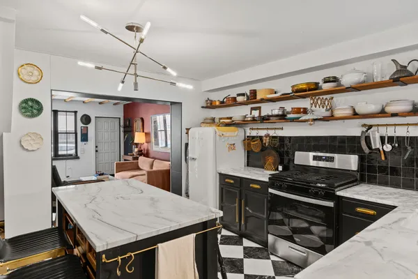 a kitchen with a stove a refrigerator and a dining table