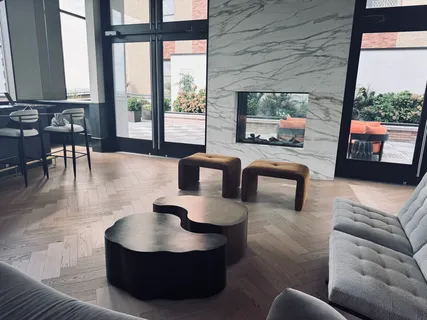 a living room with couches and a flat screen tv with kitchen view