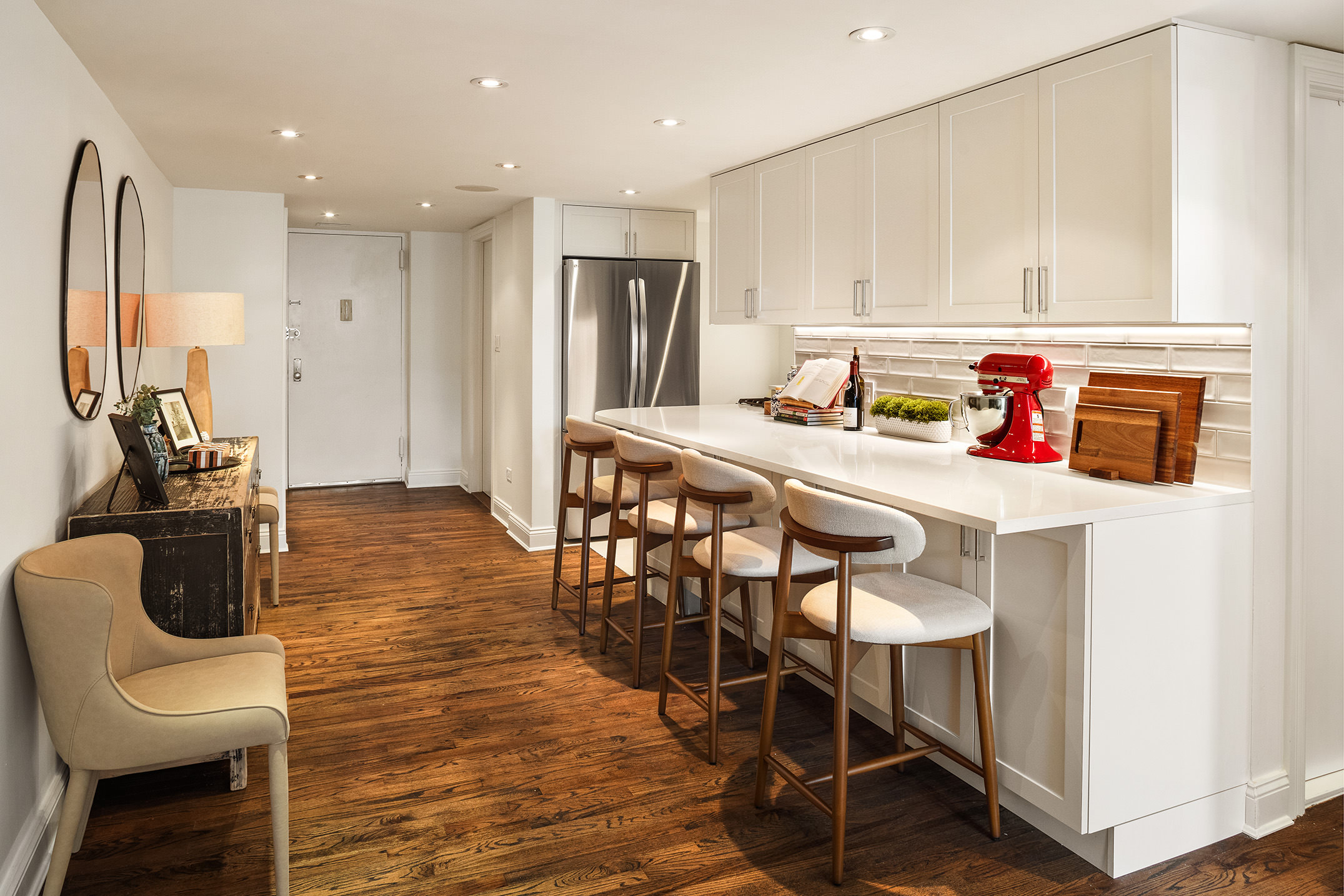 250 Mercer Street, Unit C302 Manhattan, NY 10012 - Photo 4 of 24 a kitchen with stainless steel appliances granite countertop a table chairs sink and white cabinets