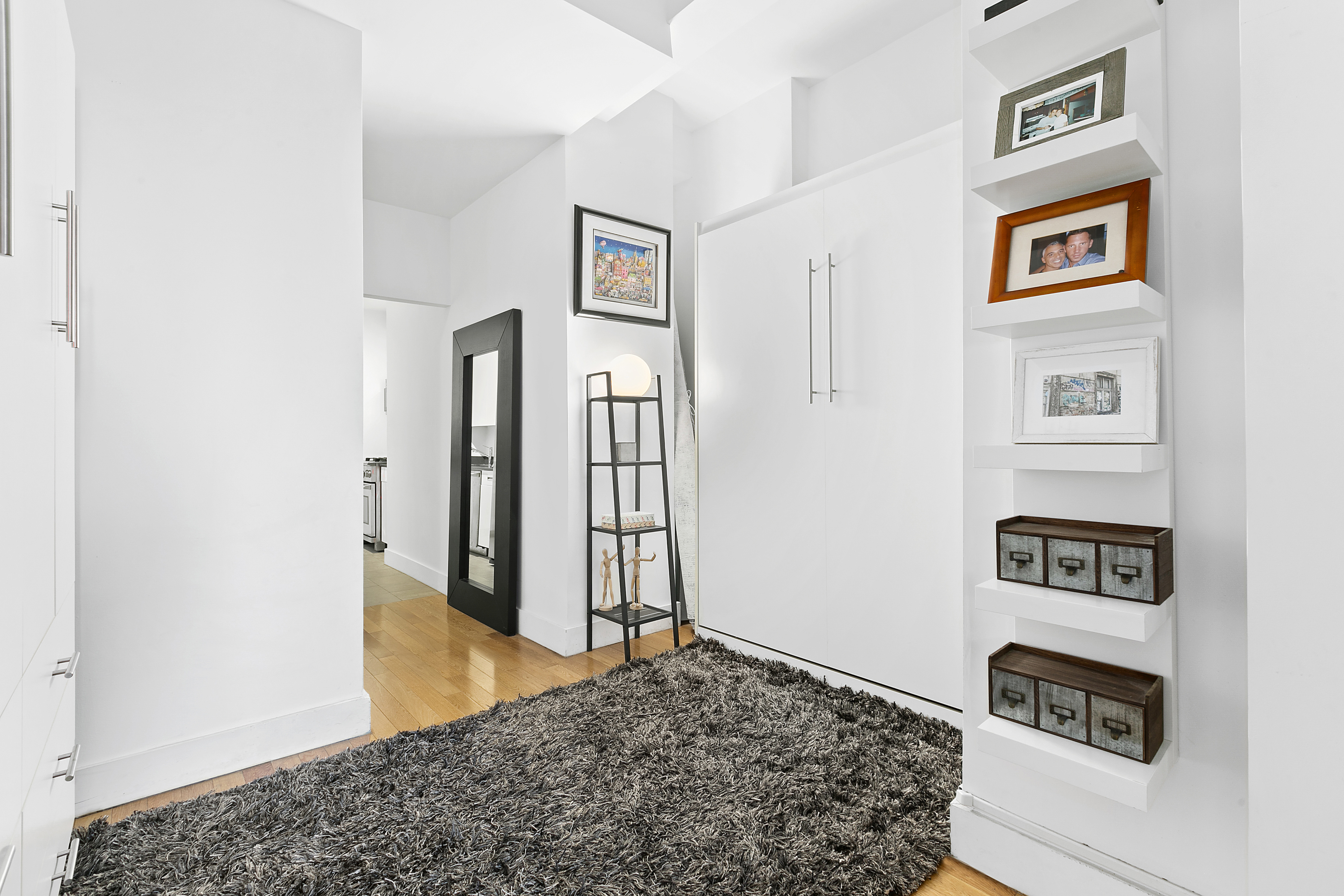 99 John Street, Unit 1101 Manhattan, NY 10038 - Photo 3 of 16 a bedroom with a bed and cabinets
