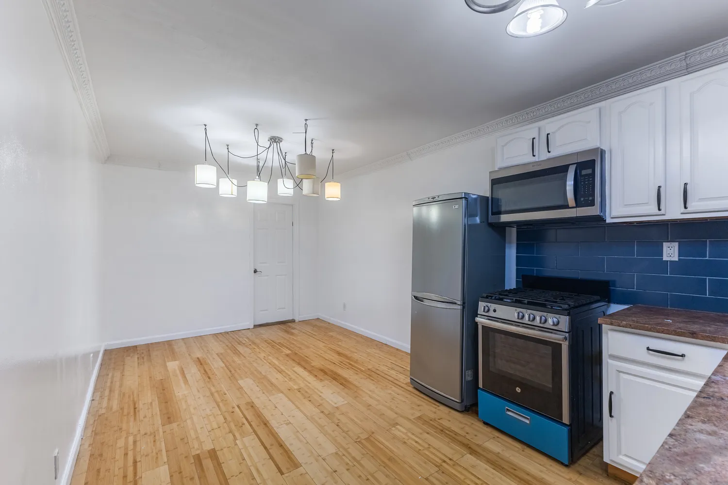a kitchen with granite countertop wooden floor stainless steel appliances and cabinets