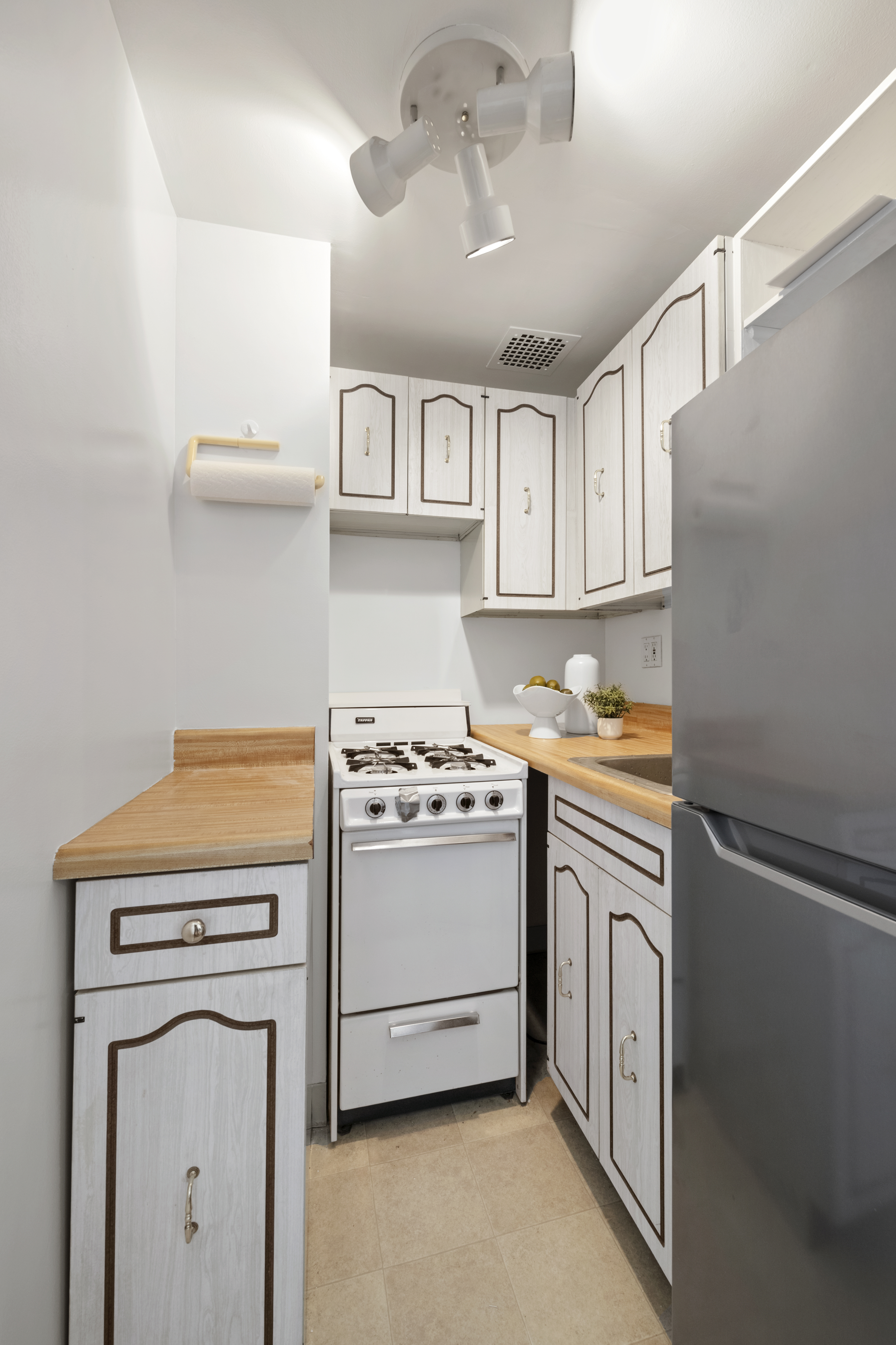 225 Central Park West, Unit 919 Manhattan, NY 10024 - Photo 4 of 15 a kitchen with stainless steel appliances a stove and a refrigerator