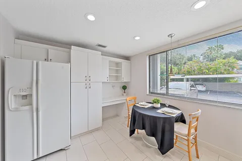 a very nice looking dining room with a large window a table and chairs