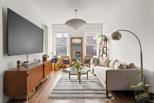 a living room with furniture and a large mirror