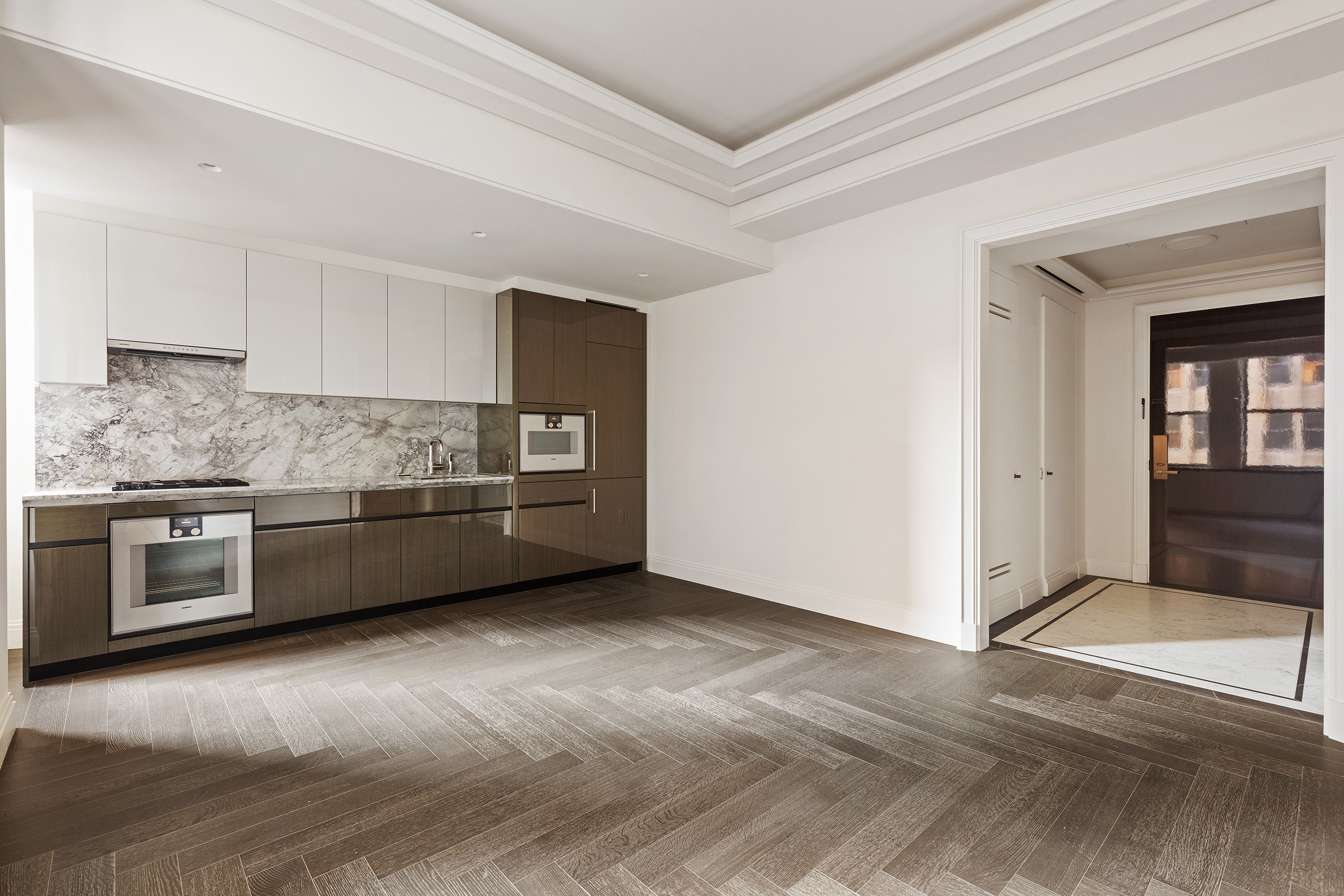 303 Park Avenue, Unit 2103 Manhattan, NY 10022 - Photo 2 of 22 a kitchen with stainless steel appliances and a wooden floor