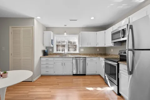 a kitchen with stainless steel appliances granite countertop a refrigerator sink and stove
