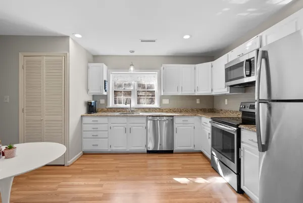 a kitchen with stainless steel appliances granite countertop a refrigerator sink and stove