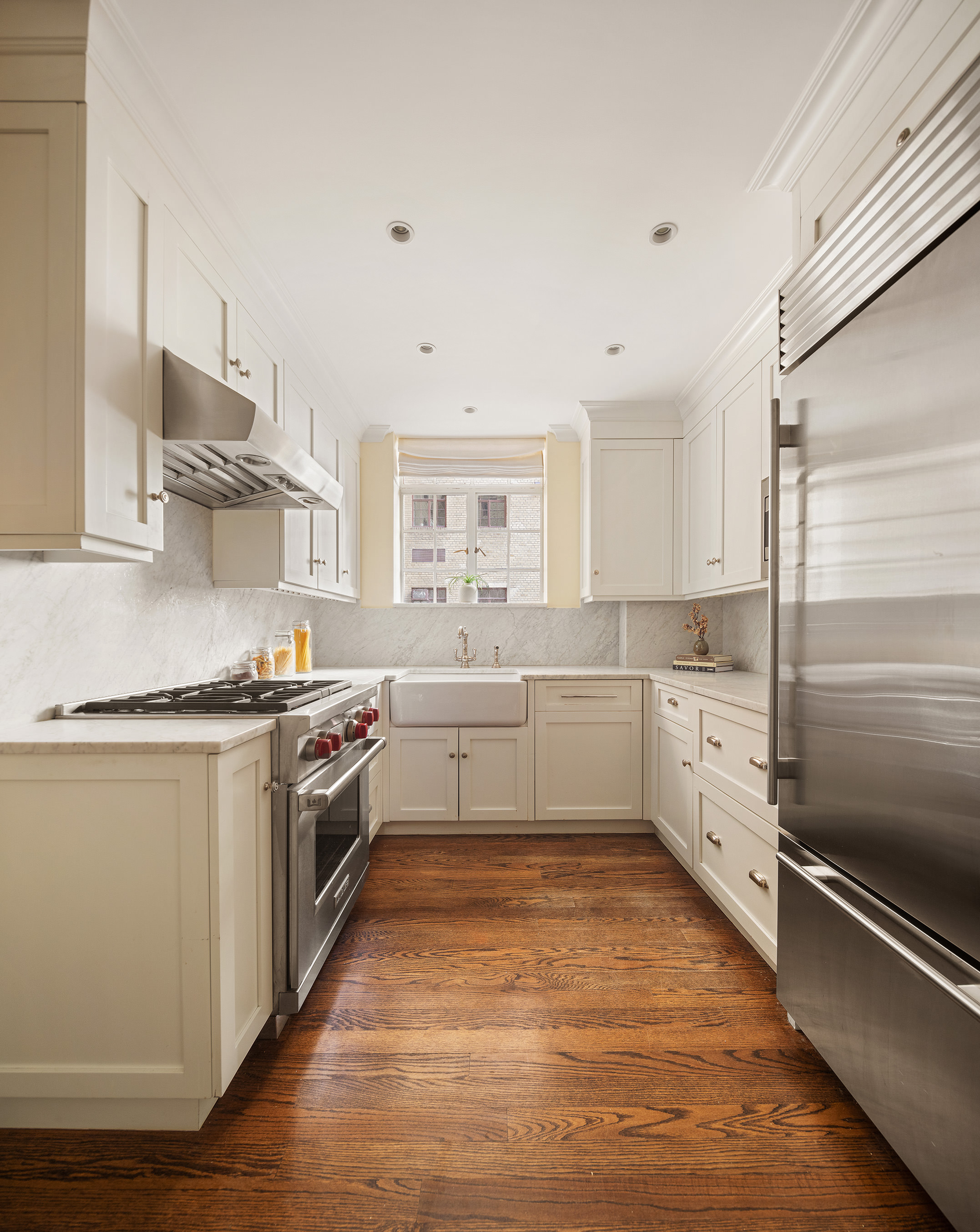 115 East 67th Street, Unit 3C Manhattan, NY 10065 - Photo 9 of 21 a large white kitchen with stainless steel appliances and white cabinets