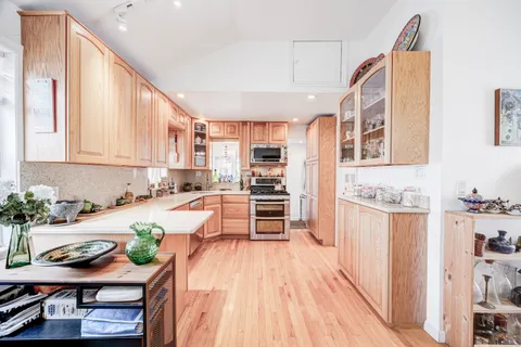 a large kitchen with a lot of counter space and wooden floor