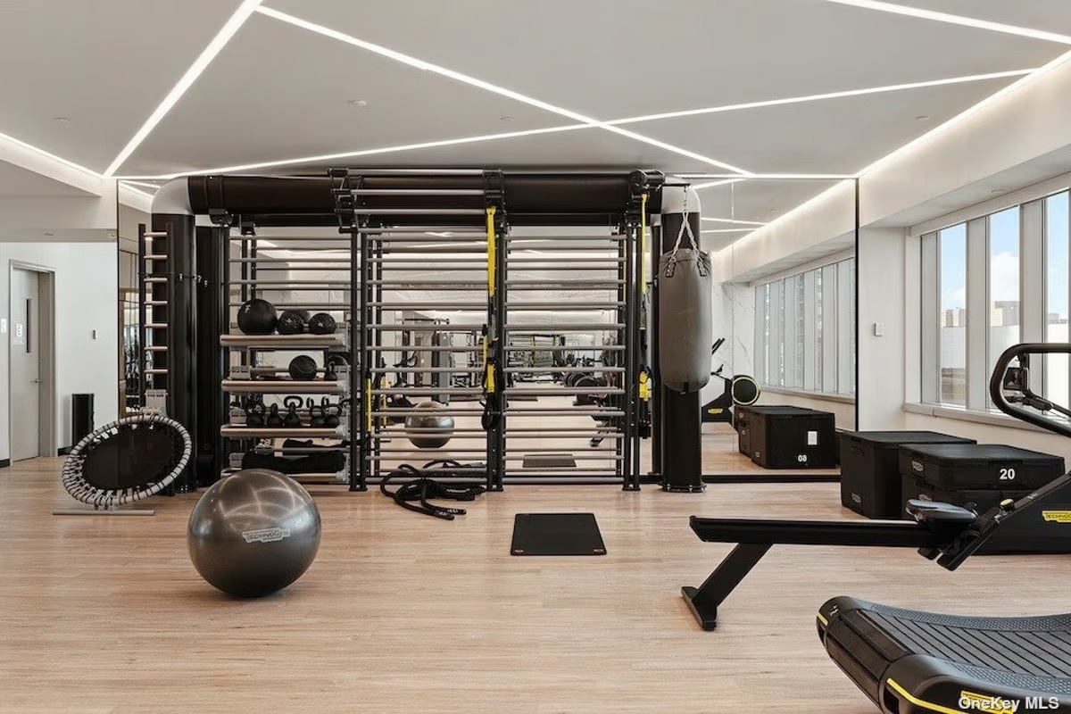 46-30 Center Boulevard, Unit PH8 Queens, NY 11109 - Photo 31 of 32 a room with gym equipment and a large window
