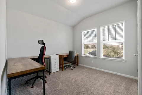 a view of a workspace with furniture and a window