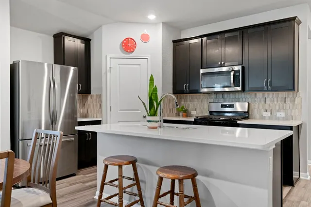 a kitchen with stainless steel appliances granite countertop a refrigerator and microwave