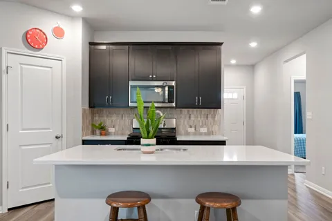 a kitchen with cabinets and wooden floor