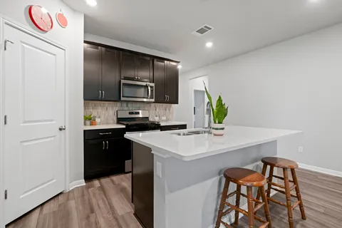 a kitchen with stainless steel appliances a sink a stove a refrigerator and a refrigerator