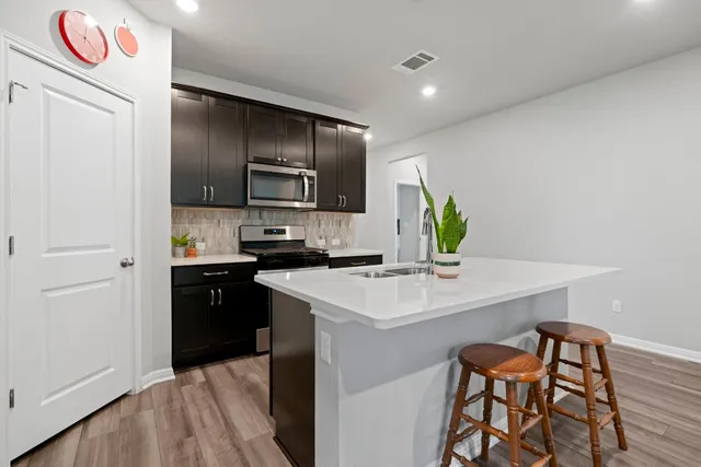 a kitchen with stainless steel appliances a sink a stove a refrigerator and a refrigerator