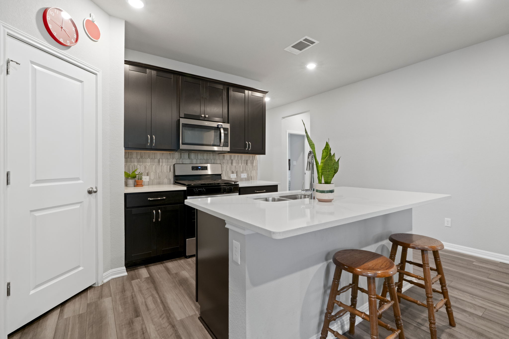 107 Magnolia Ranch Lane Hutto, TX 78634 - Photo 5 of 28 Kitchen with stainless steel appliances, a kitchen island with sink, backsplash