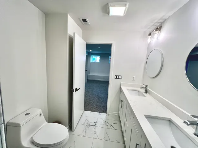 a bathroom with a sink a toilet and shower