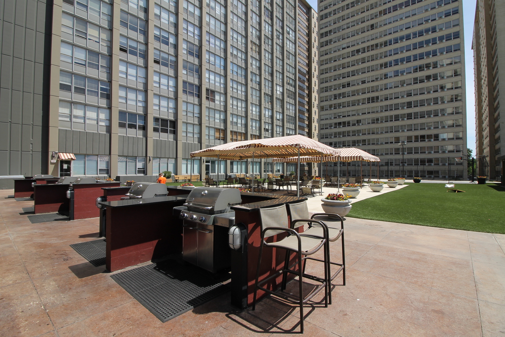 655 West Irving Park Road, Unit 1101 Chicago, IL 60613 - Photo 17 of 24 a patio with a table and chairs under an umbrella