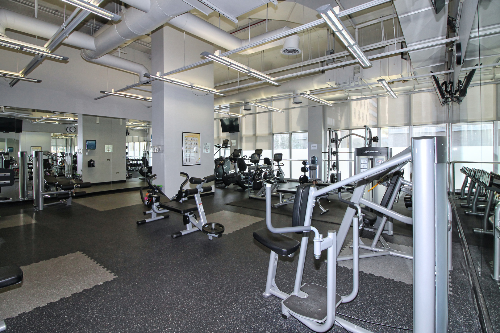 655 West Irving Park Road, Unit 1101 Chicago, IL 60613 - Photo 18 of 24 a room with gym equipment and wooden floor
