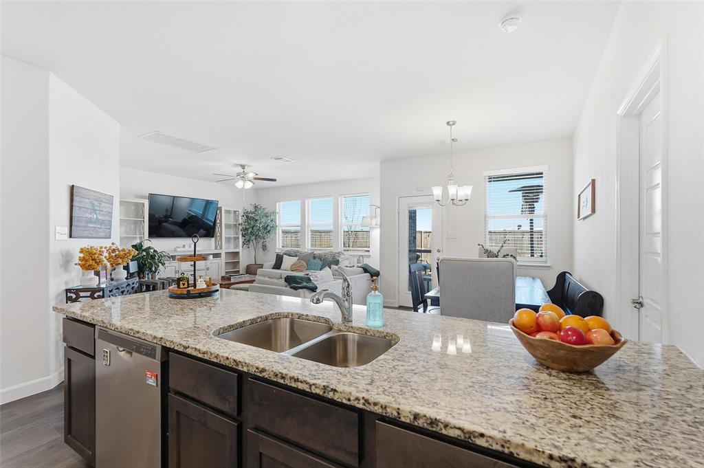 949 Philadelphia Street Fate, TX 75189 - Photo 13 of 36 a kitchen with a sink a stove and chairs