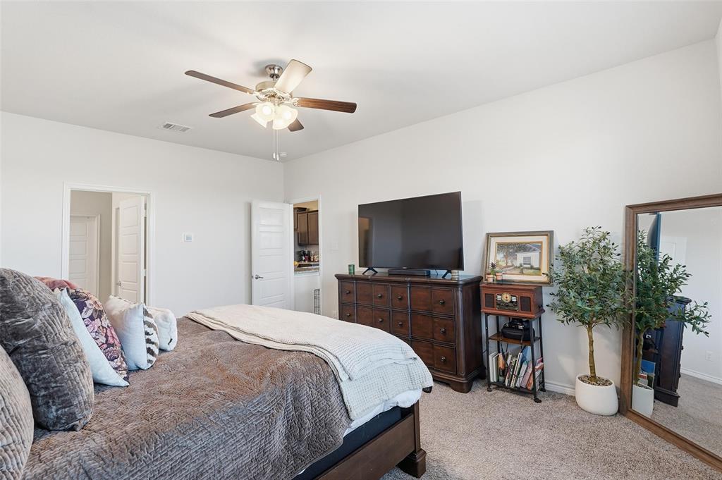 949 Philadelphia Street Fate, TX 75189 - Photo 14 of 36 a bedroom with a bed and a flat screen tv