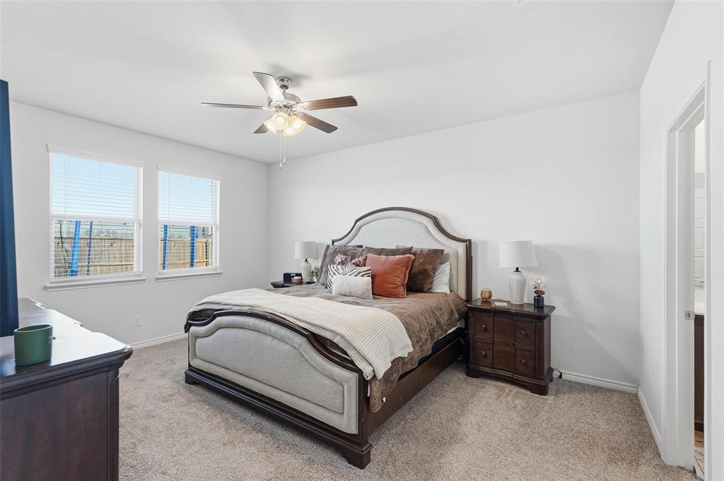 949 Philadelphia Street Fate, TX 75189 - Photo 16 of 36 a bedroom with a bed and a chandelier