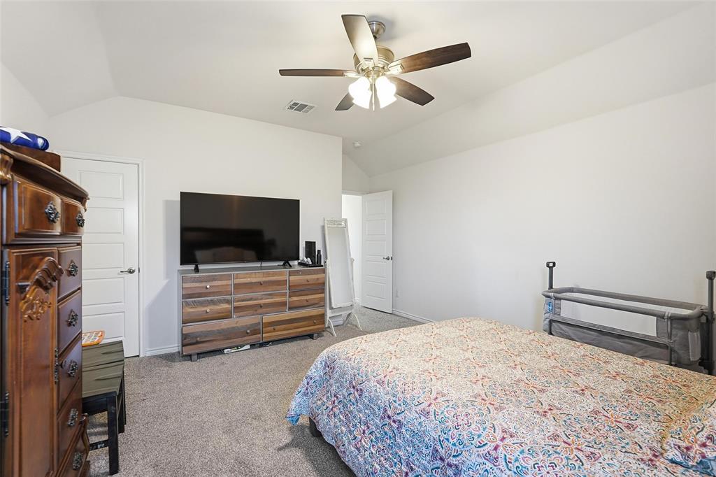 949 Philadelphia Street Fate, TX 75189 - Photo 17 of 36 a bedroom with furniture and a flat screen tv