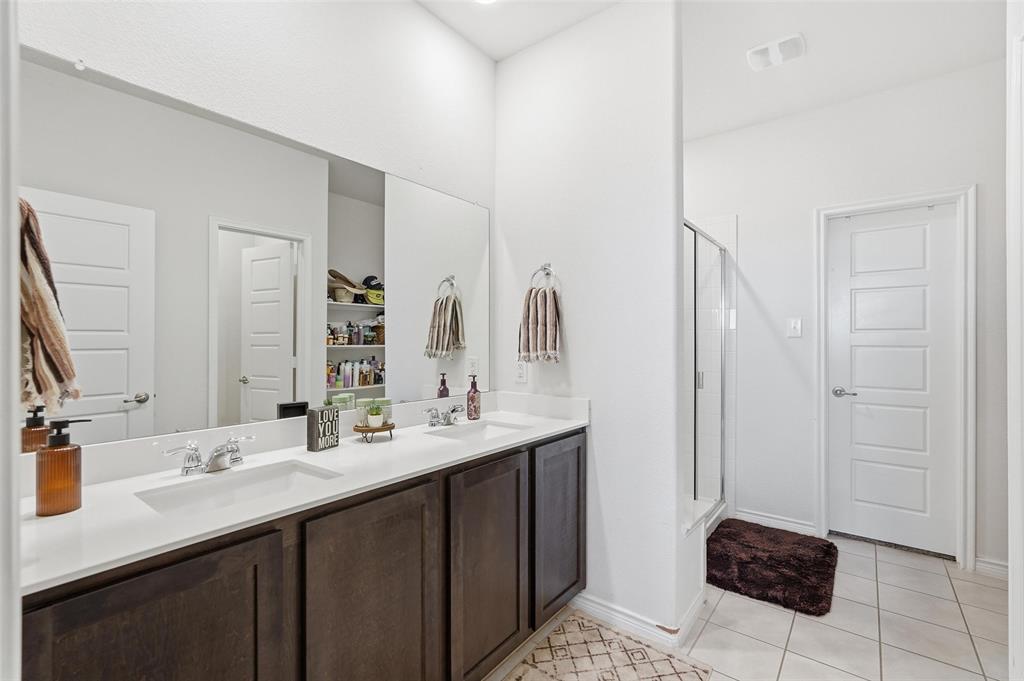 949 Philadelphia Street Fate, TX 75189 - Photo 18 of 36 a bathroom with a double sink shower and a mirror
