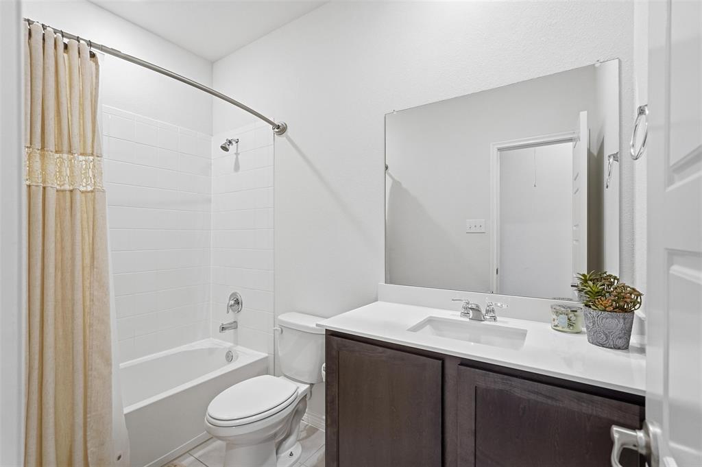 949 Philadelphia Street Fate, TX 75189 - Photo 19 of 36 a bathroom with a sink a toilet and shower