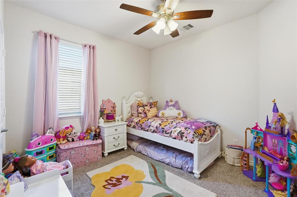 949 Philadelphia Street Fate, TX 75189 - Photo 23 of 36 a bedroom with a bed and a chandelier