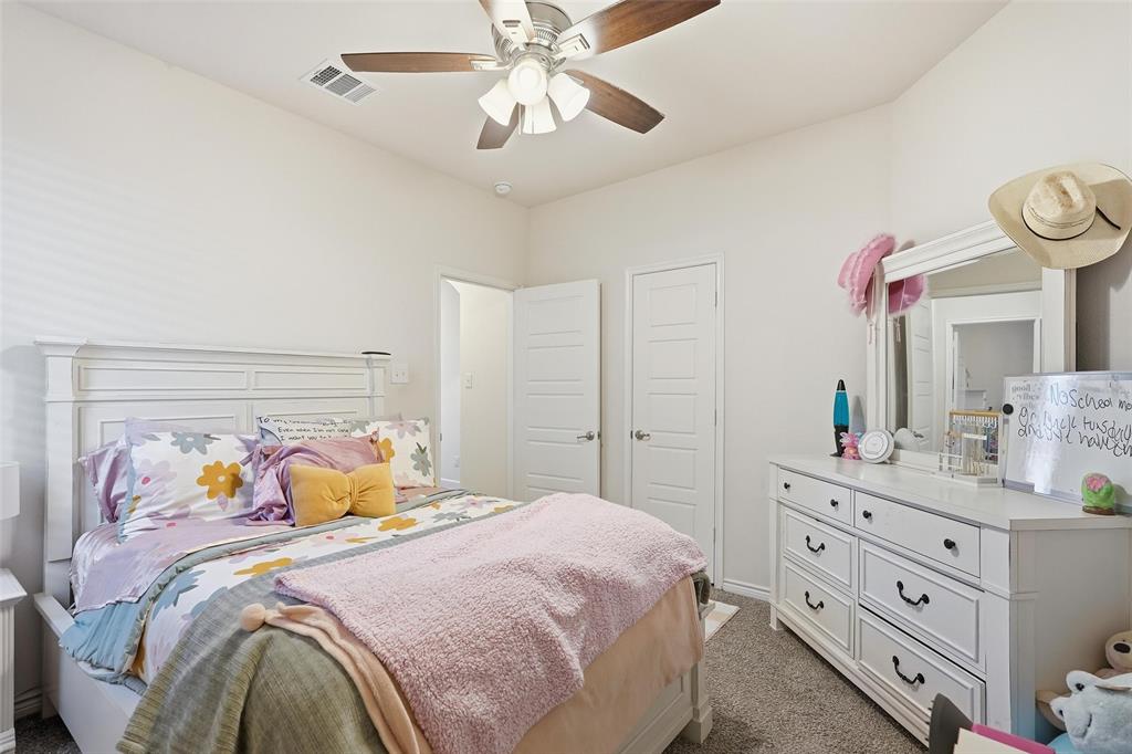 949 Philadelphia Street Fate, TX 75189 - Photo 25 of 36 a bedroom with a bed and a chandelier