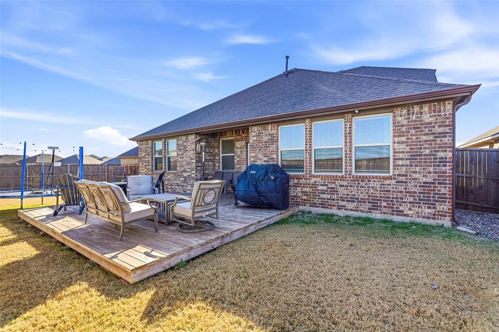 949 Philadelphia Street Fate, TX 75189 - Photo 28 of 36 a view of a patio with a dining table and chairs with wooden floor