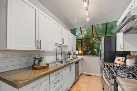 a kitchen with stainless steel appliances granite countertop a sink stove and cabinets