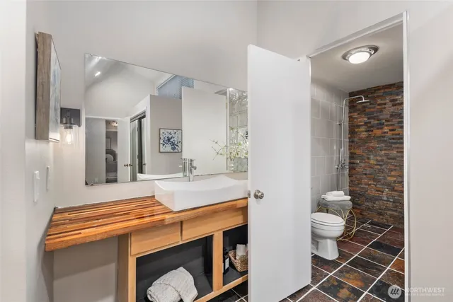 a bathroom with a sink a toilet and shower