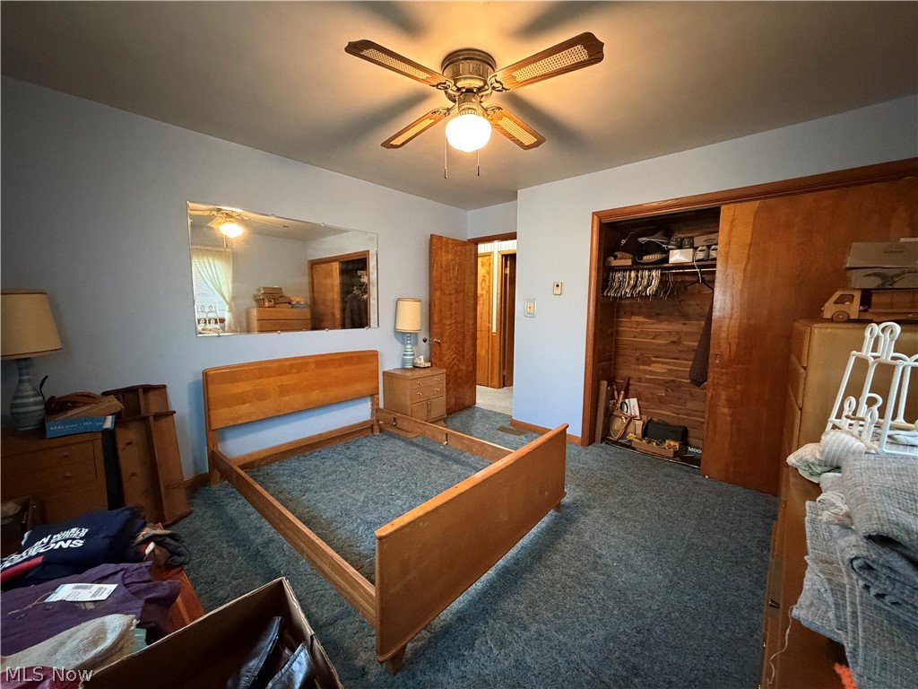 6063 East State Road Newcomerstown, OH 43832 - Photo 11 of 31 Ceiling fan with integrated lighting, wood-finish bi-fold closet doors, built-in closet shelving, and wall-mounted mirror