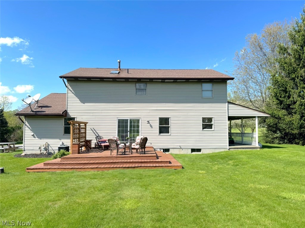 3906 Webb Road Ravenna, OH 44266 - Photo 32 of 33 Expansive rear yard featuring a multi-level wood deck, sliding glass door access, and a covered porch