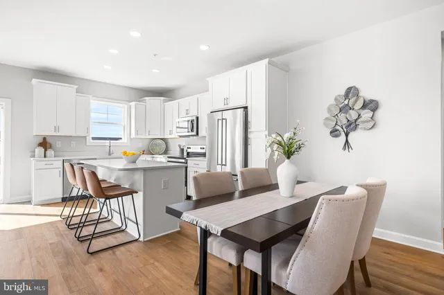 a kitchen with a dining table chairs and refrigerator